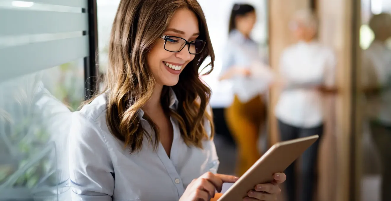 Une personne consulte sur son smartphone l'email de confirmation de validation de son compte bancaire avec une expression satisfaite